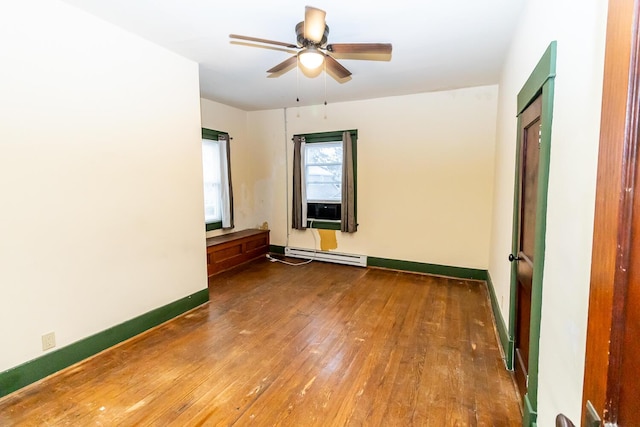 unfurnished bedroom featuring dark wood-type flooring, ceiling fan, and a baseboard heating unit