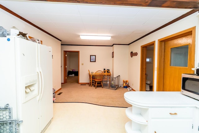 kitchen featuring light carpet, ornamental molding, white fridge with ice dispenser, and white cabinets