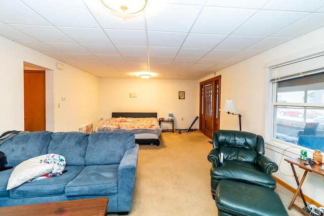 carpeted living room with a drop ceiling