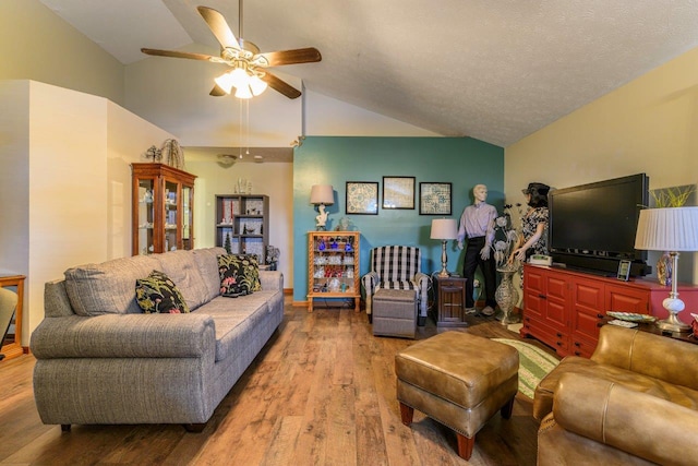 living area with lofted ceiling, ceiling fan, a textured ceiling, and wood finished floors