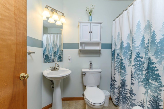 bathroom with toilet, a shower with curtain, baseboards, and tile patterned floors