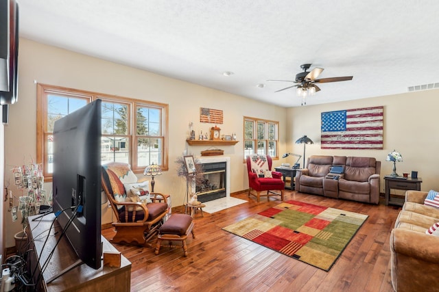 living room with hardwood / wood-style floors, ceiling fan, and a textured ceiling