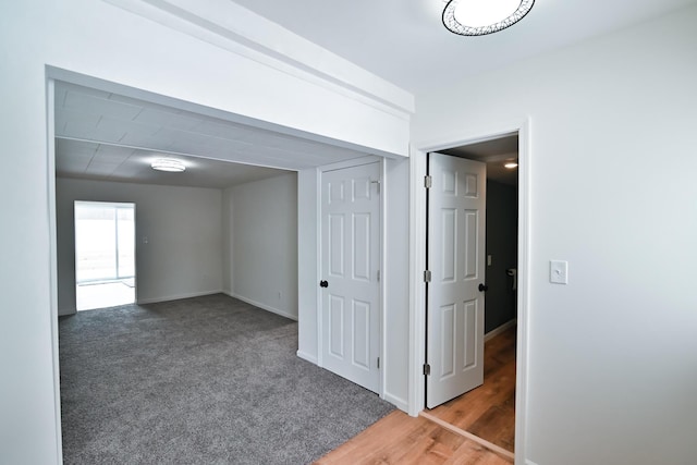 corridor with carpet flooring and baseboards