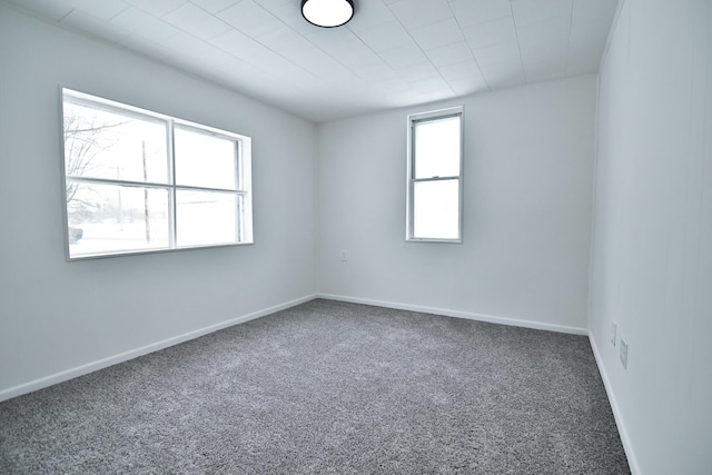 unfurnished room featuring baseboards and carpet