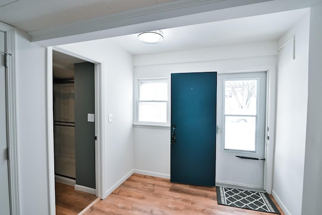 entrance foyer with plenty of natural light, baseboards, and light wood finished floors