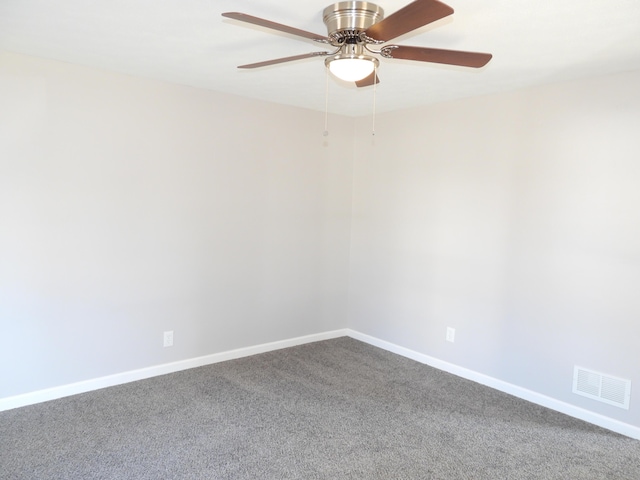 empty room featuring visible vents, baseboards, and dark colored carpet