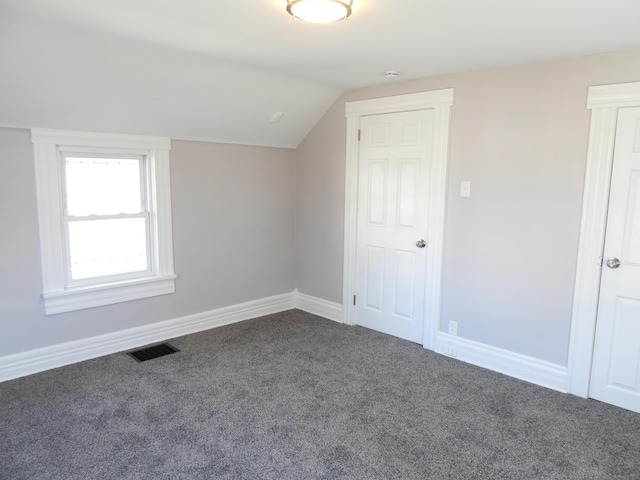 bonus room with vaulted ceiling, visible vents, baseboards, and dark colored carpet