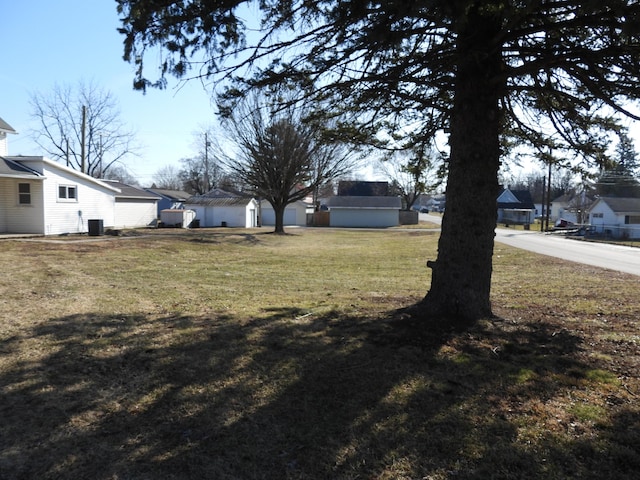 view of yard featuring central air condition unit and a residential view