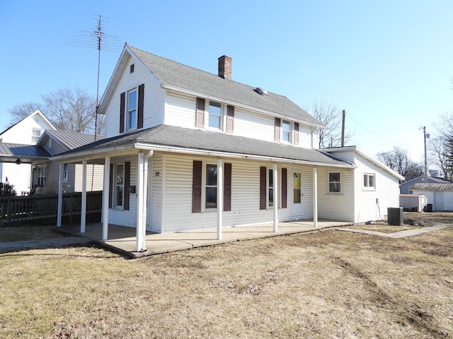 back of property with a shingled roof, fence, a chimney, a yard, and a patio