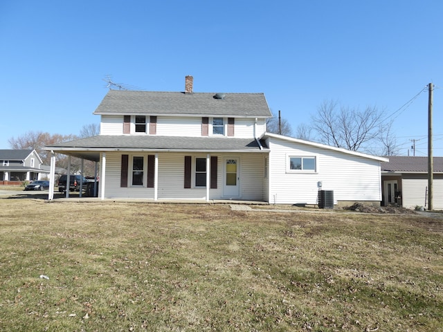 view of front of house featuring an attached carport, a chimney, and a front yard