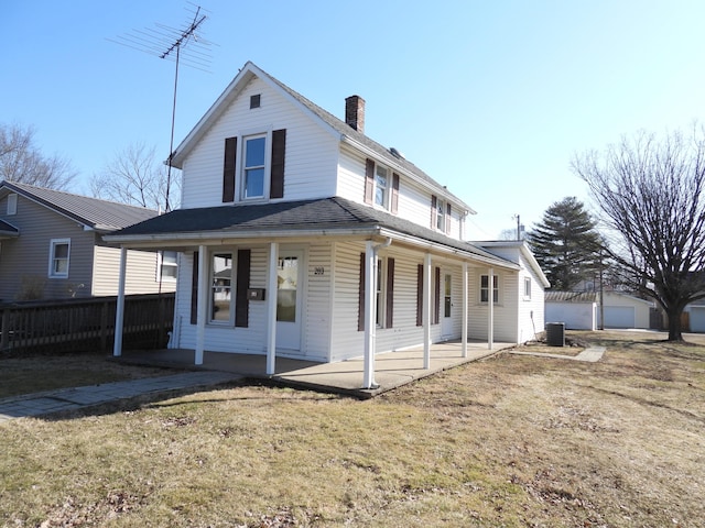 country-style home with a patio, fence, roof with shingles, a chimney, and a front lawn