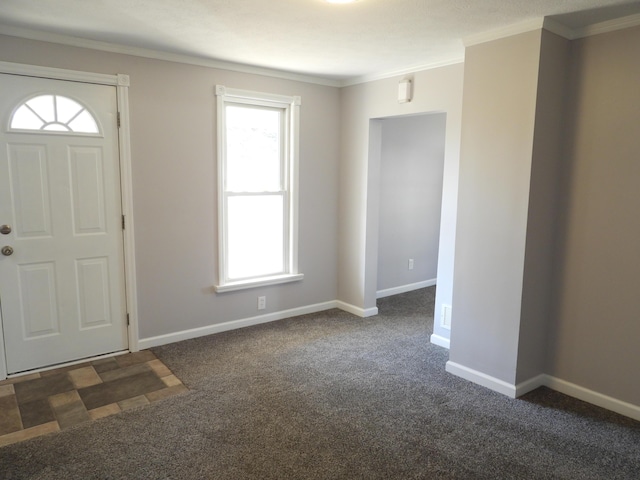 carpeted entrance foyer featuring baseboards and ornamental molding