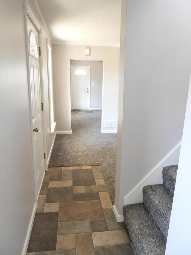 hall featuring stairway, baseboards, visible vents, and carpet flooring