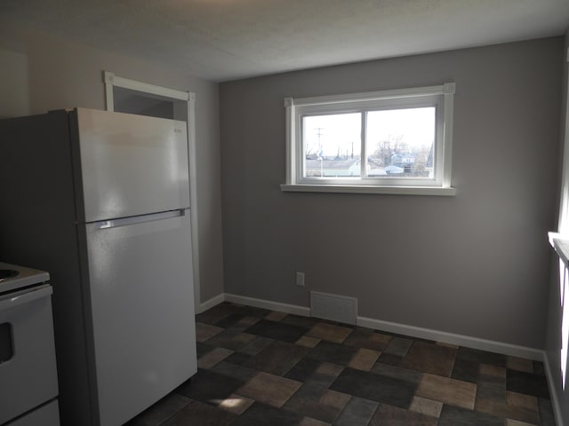 kitchen featuring white appliances, baseboards, and visible vents