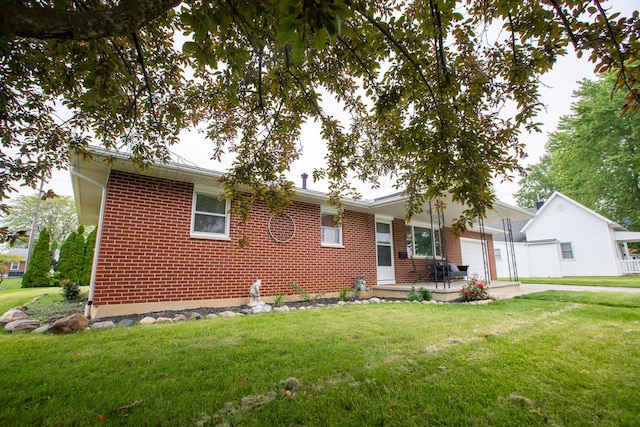 812 Motz St, Saint Marys, OH 45885 - single story home with brick siding, an attached garage, a front lawn, and concrete driveway