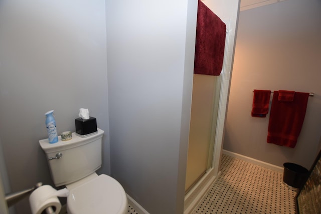 bathroom with toilet and a shower with shower door