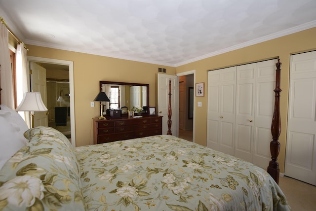 carpeted bedroom featuring crown molding and ensuite bath