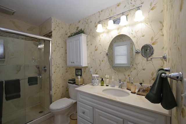 bathroom with vanity, toilet, and a shower with shower door