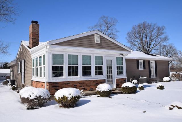 snow covered property with central AC unit