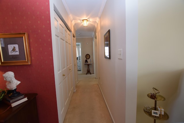 hall with ornamental molding and light colored carpet