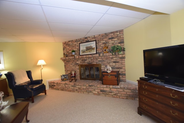 living room with light colored carpet, a brick fireplace, and a drop ceiling