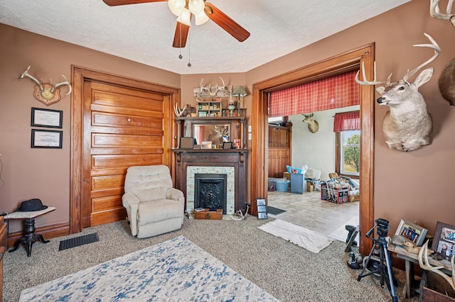 4711 N Elm Tree Rd, Conover, OH 45317 - living room with carpet floors, a fireplace with flush hearth, a ceiling fan, and a textured ceiling