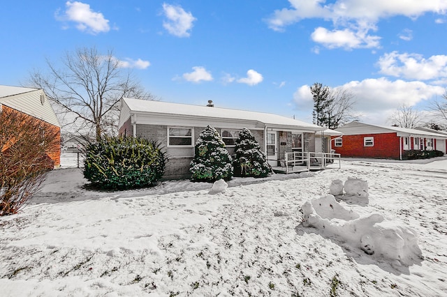 snow covered property with covered porch