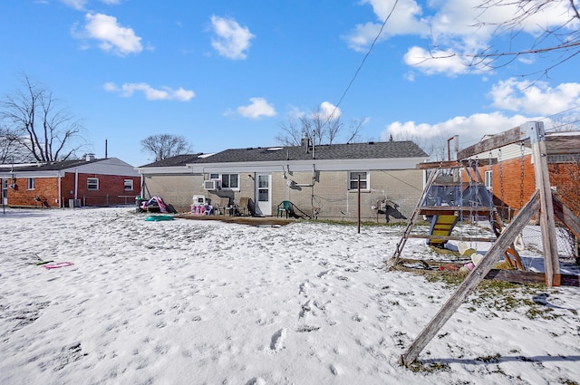 snow covered house with a playground