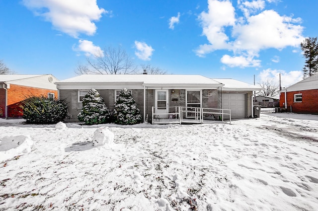 snow covered property with a garage and a porch