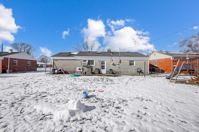 snow covered property featuring a playground