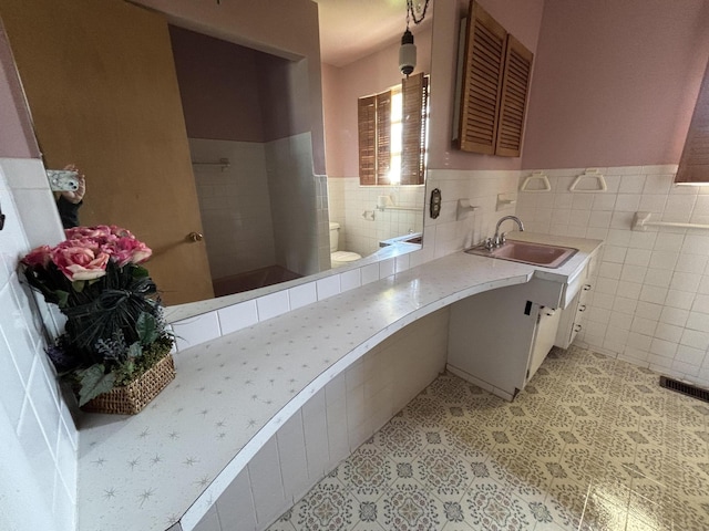 10081 Forest St, Lakeview, OH 43331 - bathroom with tile walls, tiled shower, a wainscoted wall, toilet, and vanity