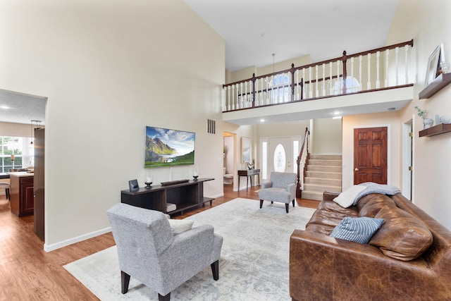 170 Fox Harbor Dr, Troy, OH 45373 - living area featuring healthy amount of natural light, stairway, light wood-type flooring, and a towering ceiling