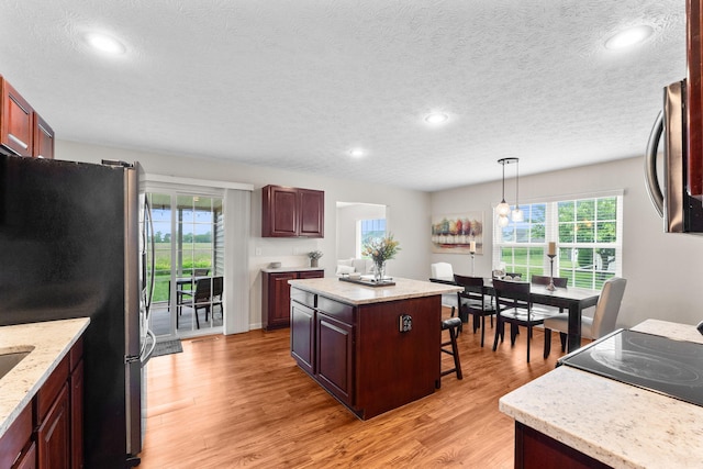 170 Fox Harbor Dr, Troy, OH 45373 - kitchen with freestanding refrigerator, a breakfast bar, light wood-style flooring, a kitchen island, and recessed lighting