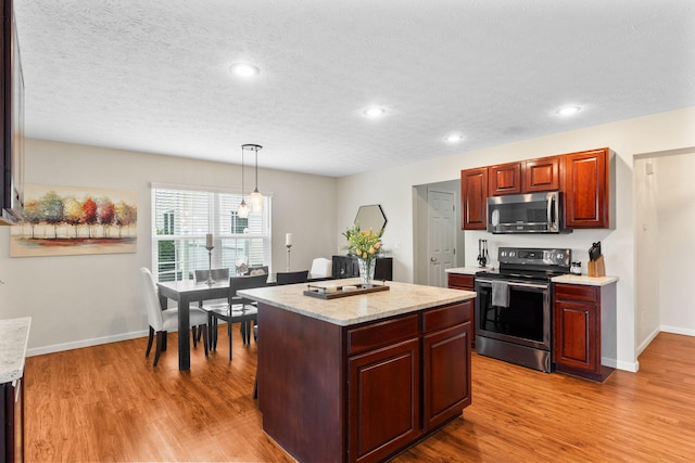 170 Fox Harbor Dr, Troy, OH 45373 - kitchen with appliances with stainless steel finishes, light wood-style flooring, a center island, decorative light fixtures, and recessed lighting