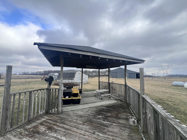 view of dock with a rural view, a yard, and a deck