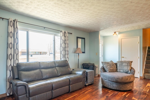 living area featuring hardwood / wood-style floors, stairway, and a textured ceiling