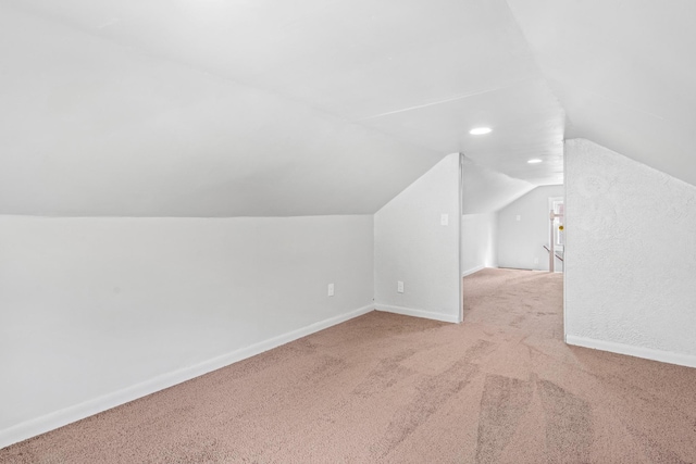 bonus room featuring vaulted ceiling and light carpet