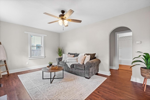 living room with dark wood-type flooring and ceiling fan