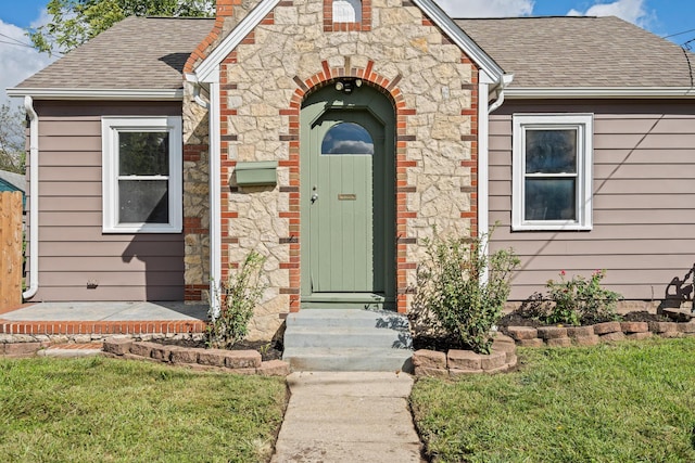 property entrance with a lawn