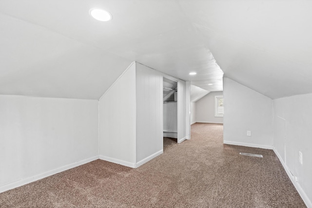 additional living space with vaulted ceiling and carpet