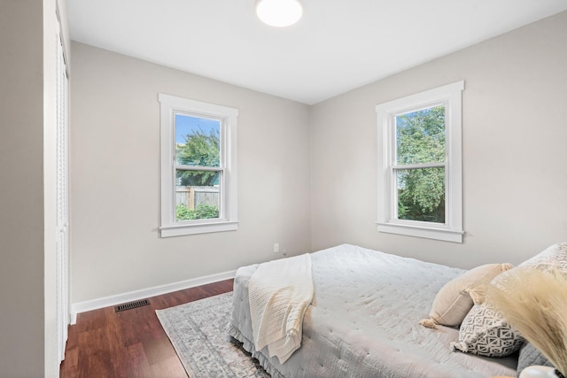 bedroom with dark hardwood / wood-style floors