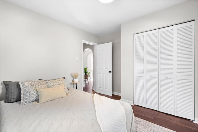 bedroom with dark wood-type flooring and a closet