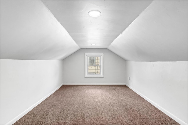 additional living space with carpet floors and vaulted ceiling