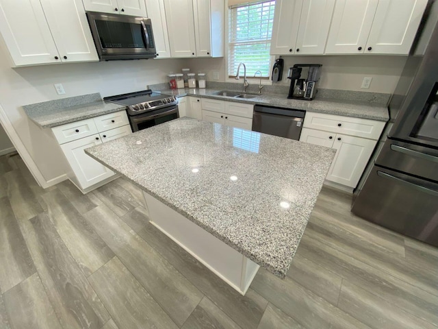 200 Malone Ave, Bellefontaine, OH 43311 - kitchen featuring a sink, stainless steel appliances, wood finished floors, and white cabinets