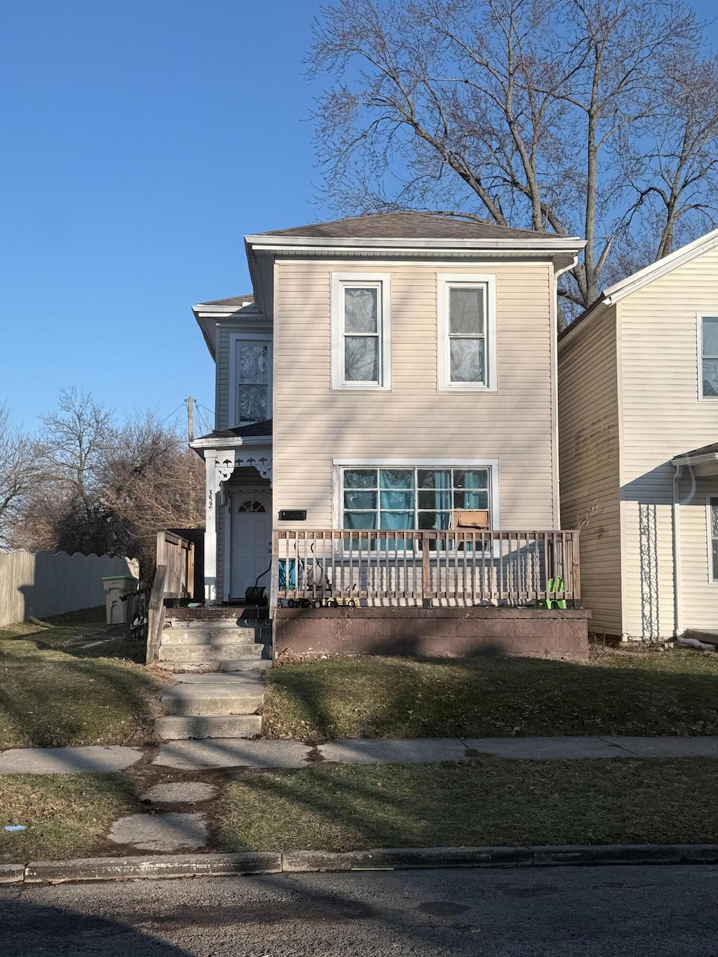 traditional-style home featuring a front lawn and fence