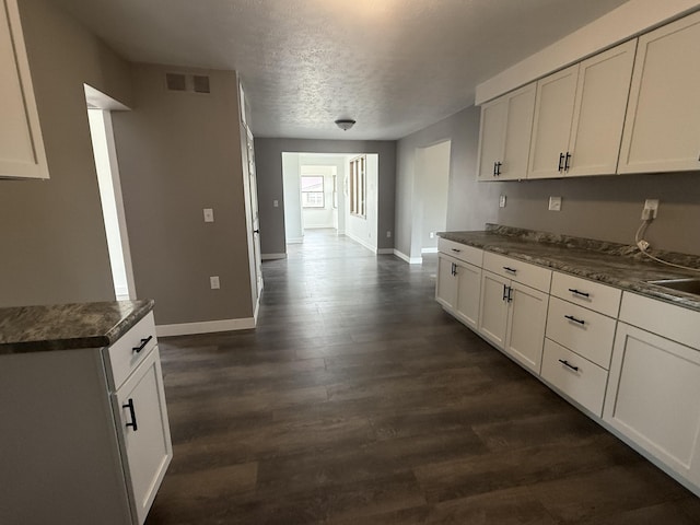 158 E Walnut St, Rockford, OH 45882 - kitchen featuring dark countertops, a textured ceiling, dark wood finished floors, and white cabinetry