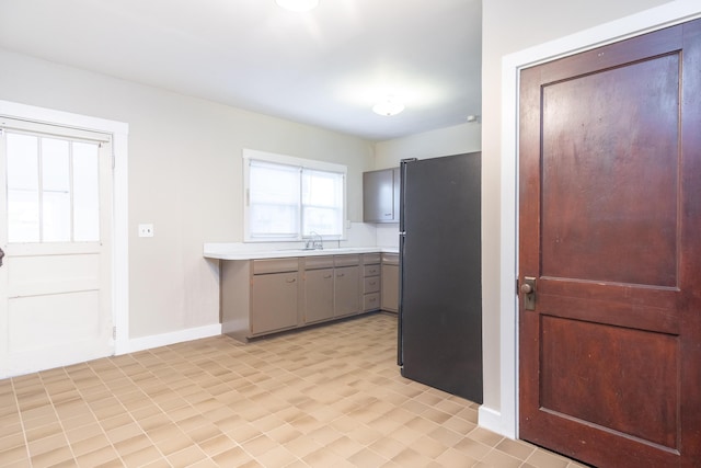 kitchen with sink, gray cabinets, and black fridge