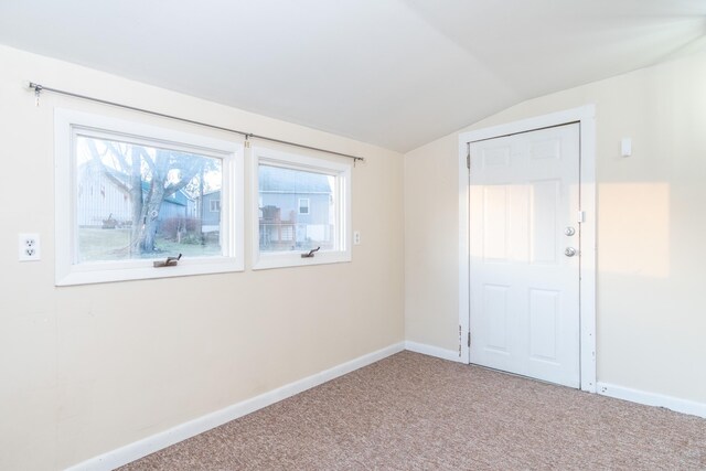 spare room with plenty of natural light, carpet floors, and lofted ceiling