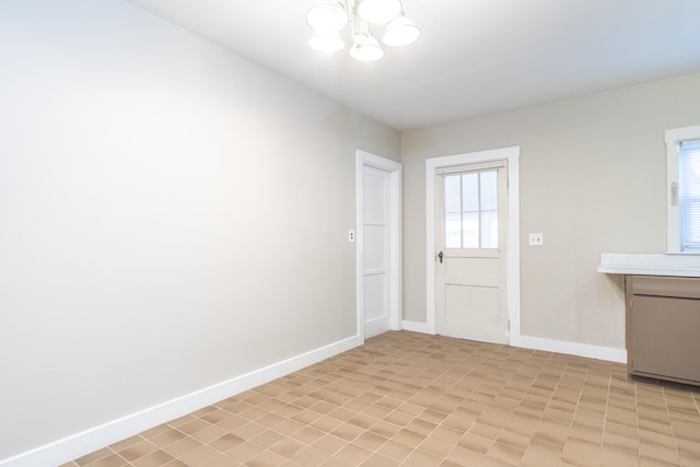 doorway to outside featuring an inviting chandelier