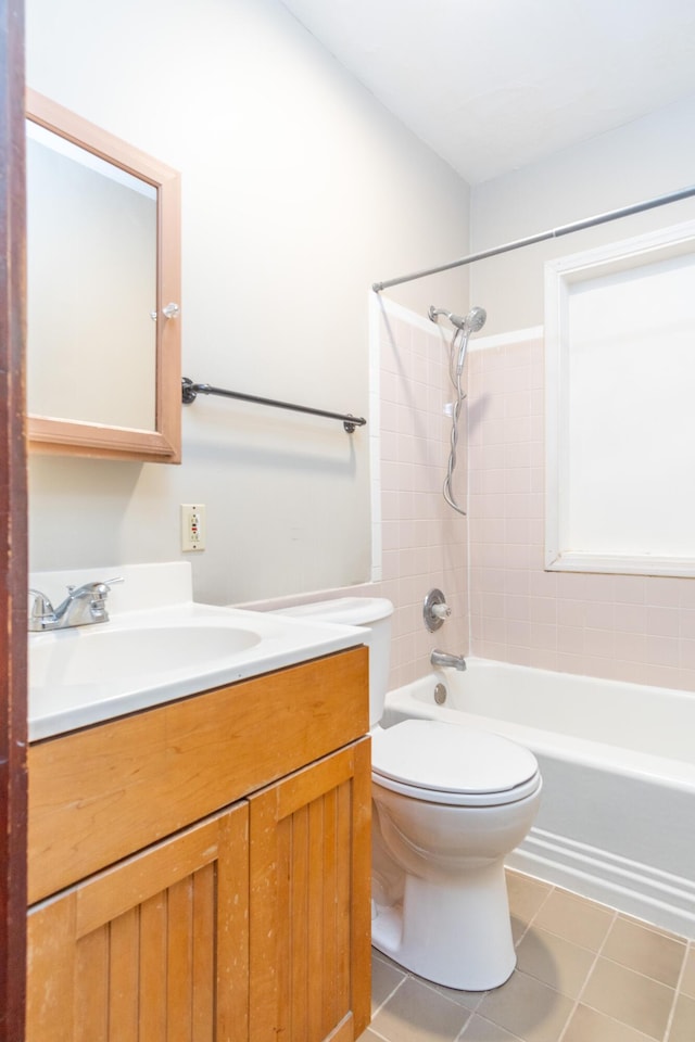 full bathroom featuring vanity, tiled shower / bath, tile patterned floors, and toilet